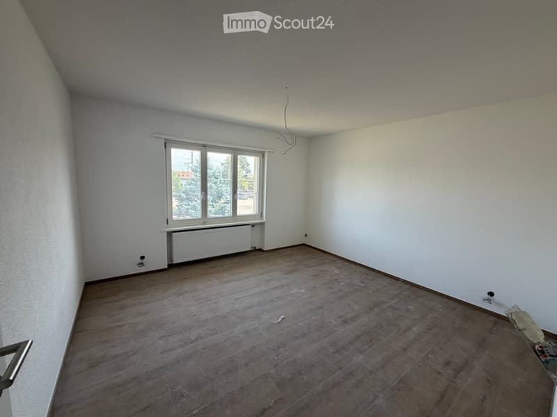 Empty room with wooden flooring, white walls, and a window with a radiator below it. No furniture or equipment is present.