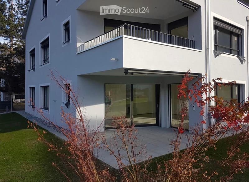 Modern two-story house with white exterior, large windows, and a balcony on the upper level.