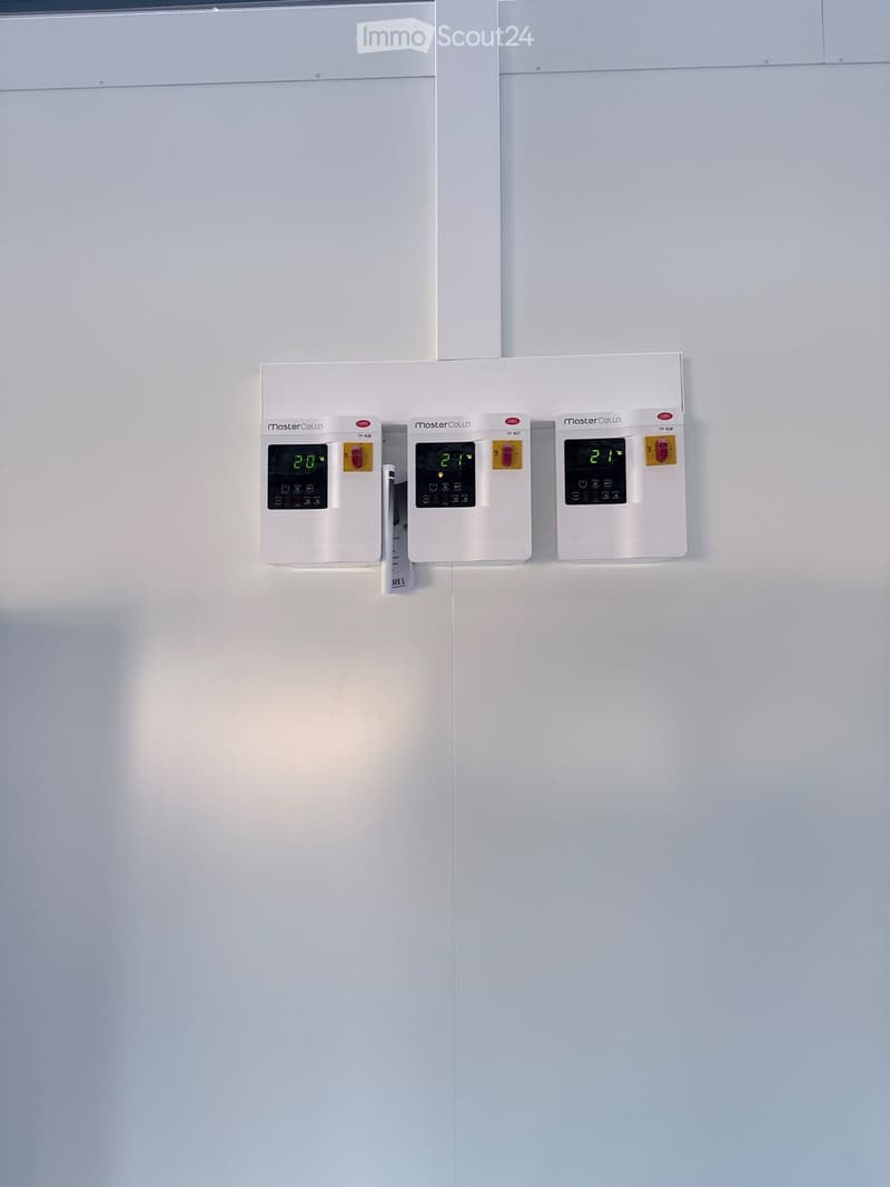 Three white thermostats mounted on a wall, displaying temperatures of 20°C, 21°C, and 21°C respectively.