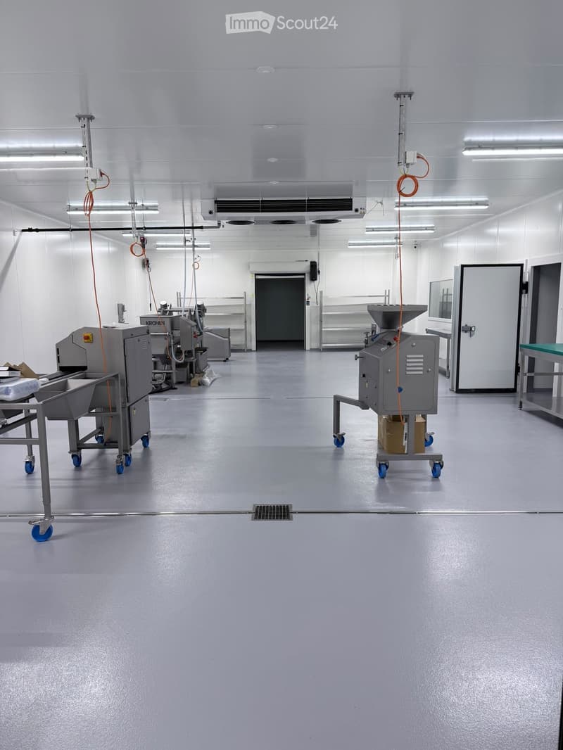 Clean, industrial-style room with stainless steel equipment, large doors, and a polished floor.