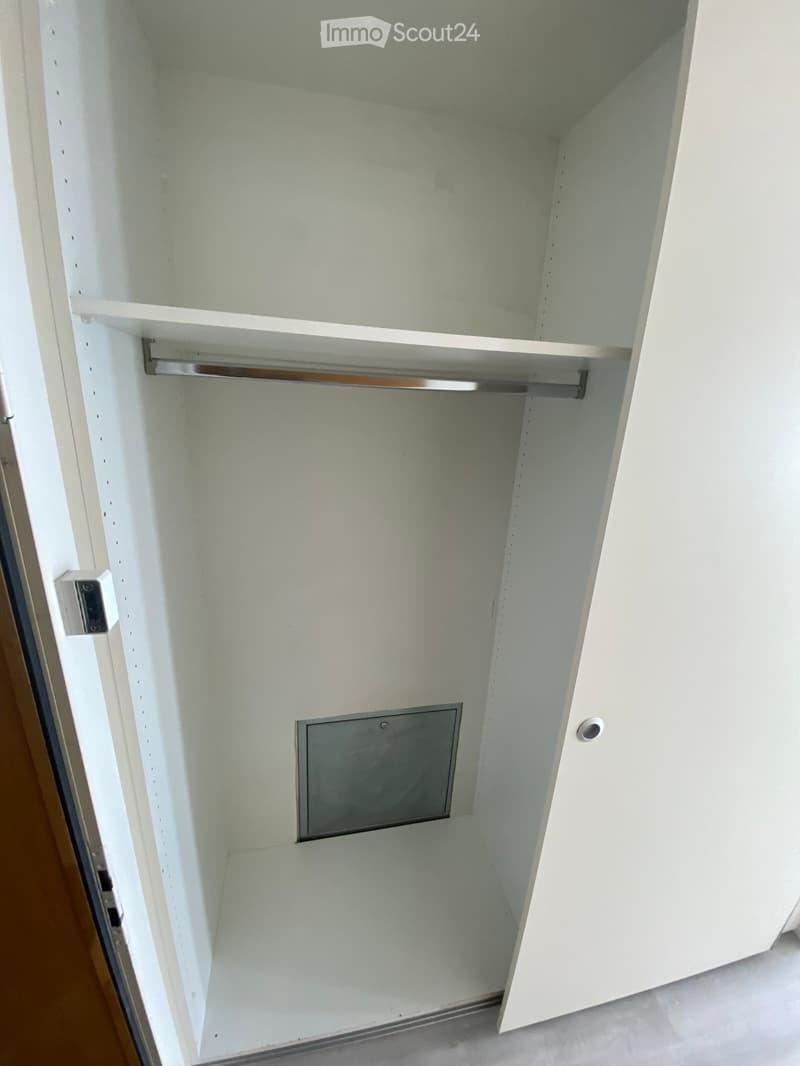 Empty closet with white walls, two shelves, and a hanging rod. No furniture or items present.