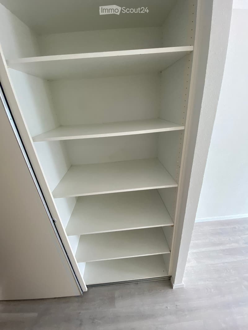 Empty built-in closet with multiple white shelves, no items or furniture present.
