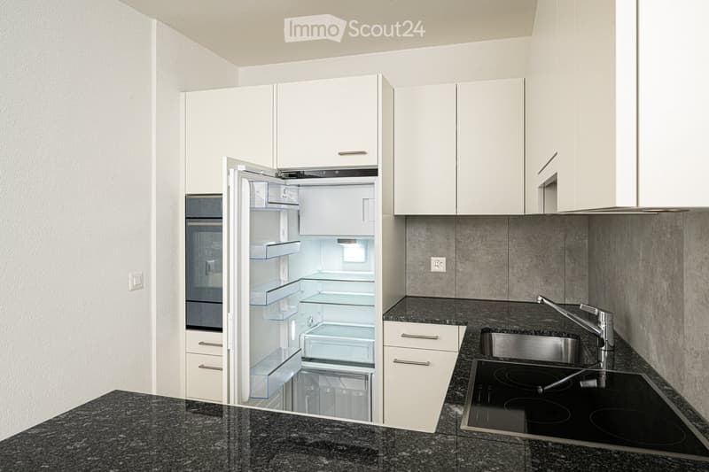 Modern kitchen with white cabinets, granite countertops, stainless steel sink, electric stove, and open refrigerator.
