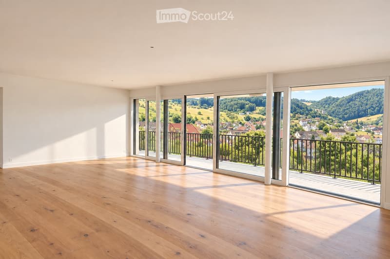 Empty room with wooden flooring, large sliding glass doors leading to a balcony with a scenic countryside view.