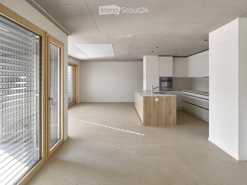 Modern, minimalist kitchen with white cabinets, a wooden island, and a stainless steel oven. The space features large windows and a clean, open layout.