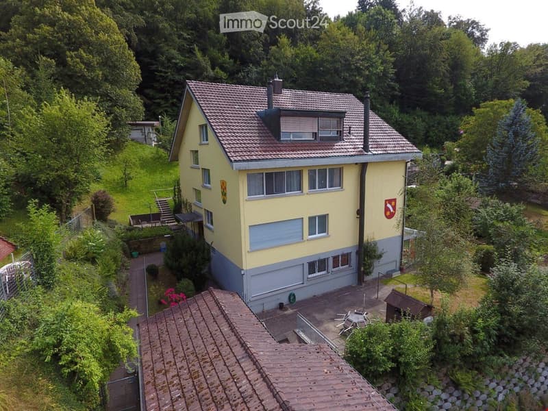 2 story house, yellow exterior, brown roof, two chimneys, attached garage