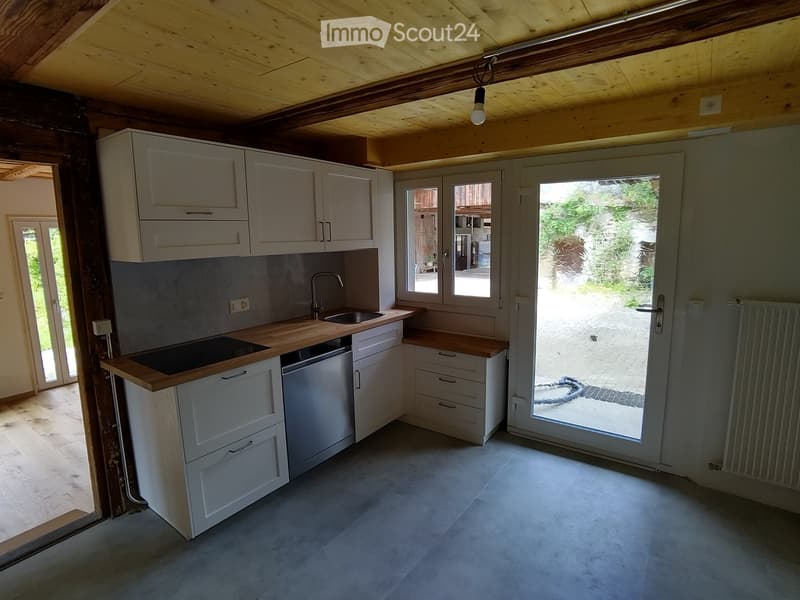 Kitchen. Modern kitchen with white cabinets, wooden countertops, stainless steel appliances, and a glass door leading to an outdoor area.