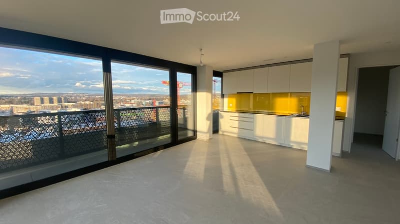Modern, unfurnished kitchen with white cabinets, a yellow backsplash, and a large window offering a city view. The space includes a sink and faucet, with a balcony accessible through large glass doors.