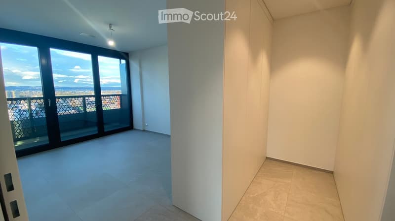 Empty room with large sliding glass doors leading to a balcony, tiled floor, and white walls.