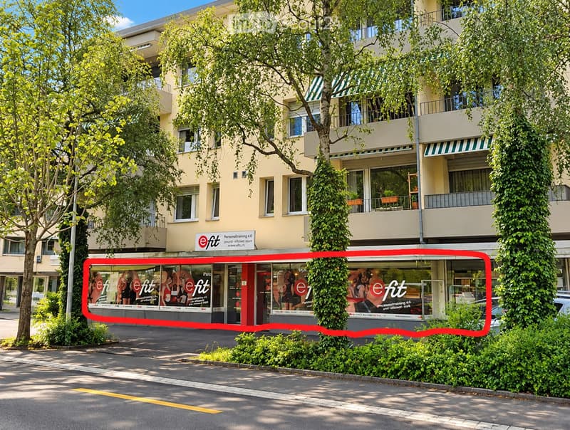 Multi-story building with light yellow facade, multiple windows, balconies, and greenery. A storefront with the sign "eFit" is visible at the bottom.