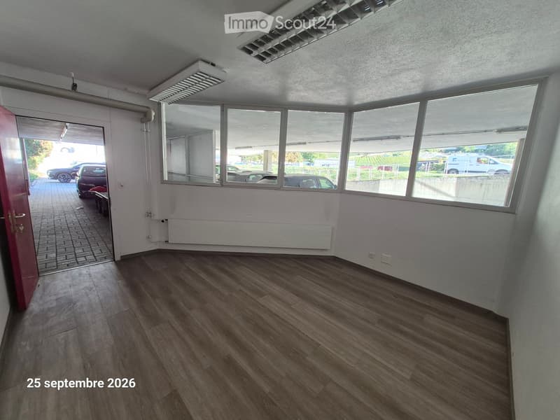 Empty room with wooden flooring, large windows, and a door leading to an outdoor area.