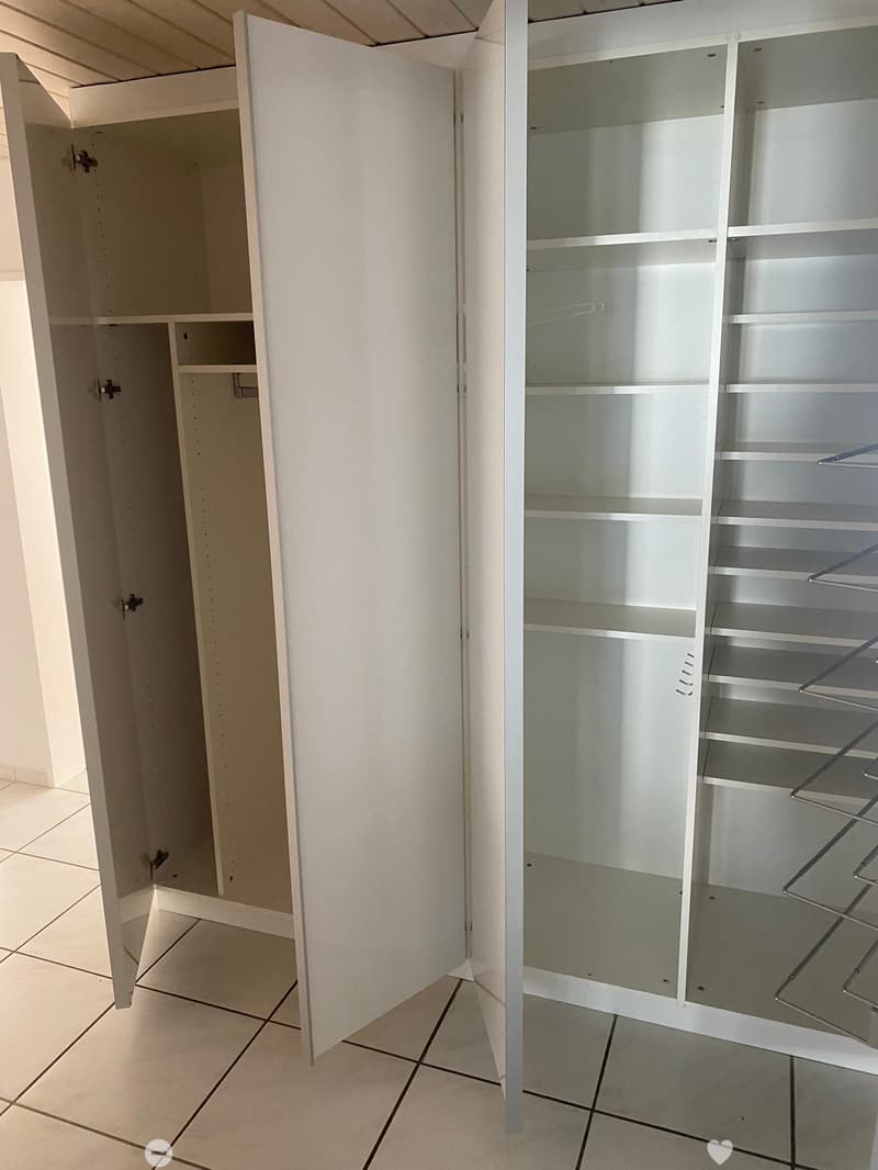 Empty room with white built-in cabinets and shelves, tiled floor, and neutral-colored walls.