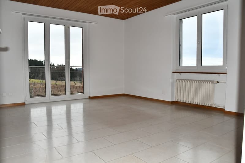 Empty room with white walls, wooden ceiling, large sliding glass doors, and tiled floor.