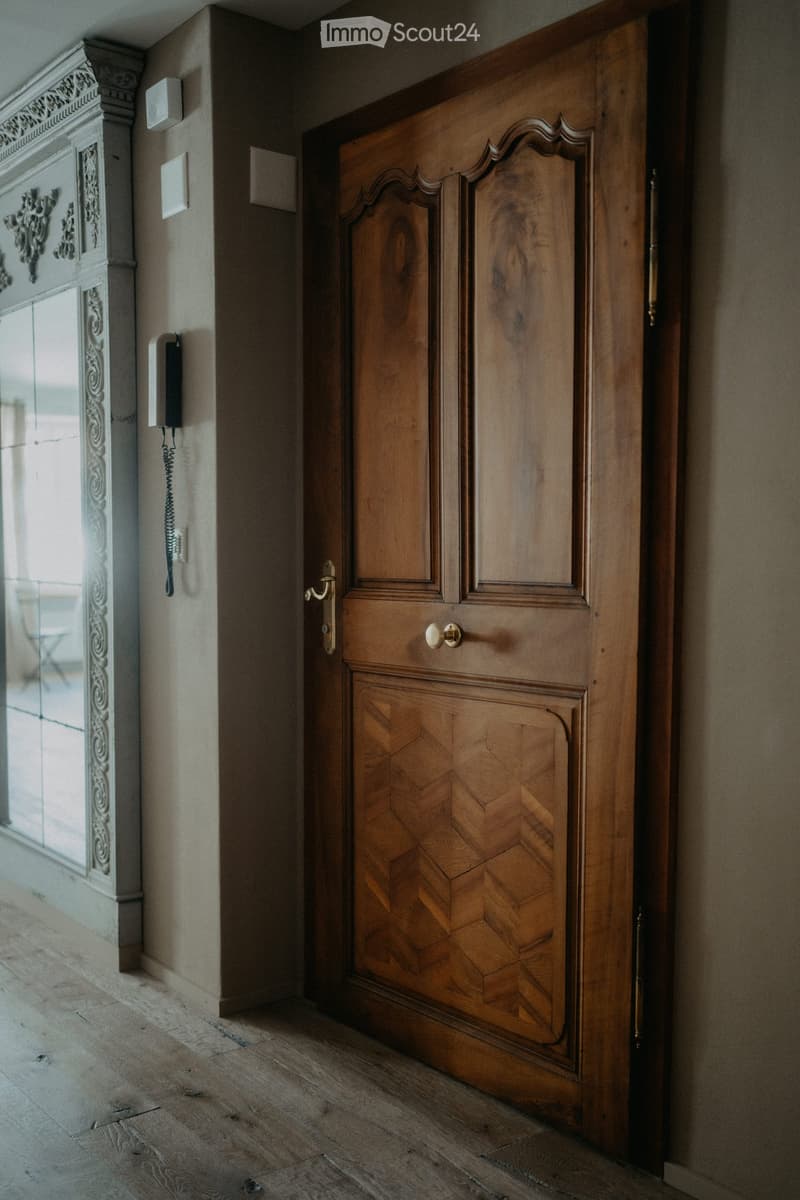 wooden door, wooden floor, beige wall, mirror with decorative elements