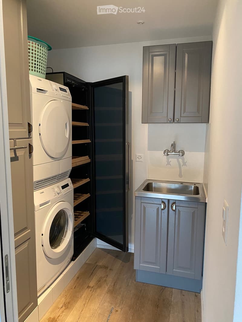 laundry area with stackable washer and dryer, open cabinetry, sink, power outlet, and laundry basket