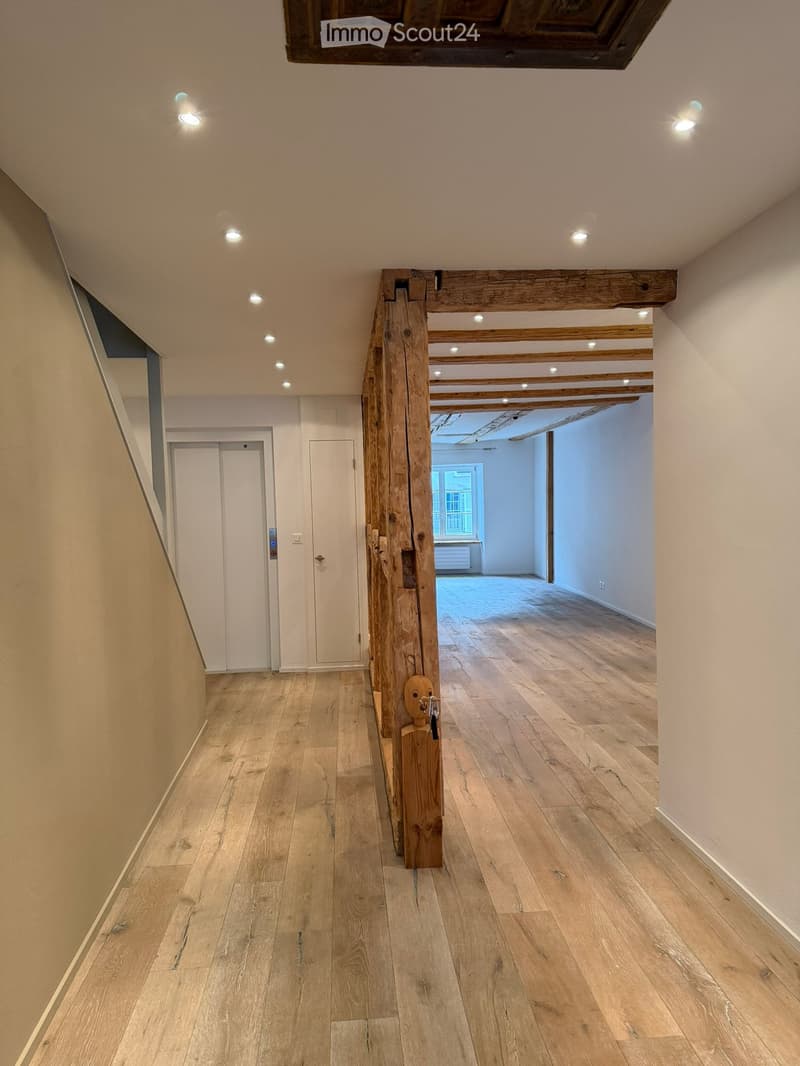 Empty corridor, wooden beam, hardwood floors, white walls, radiator