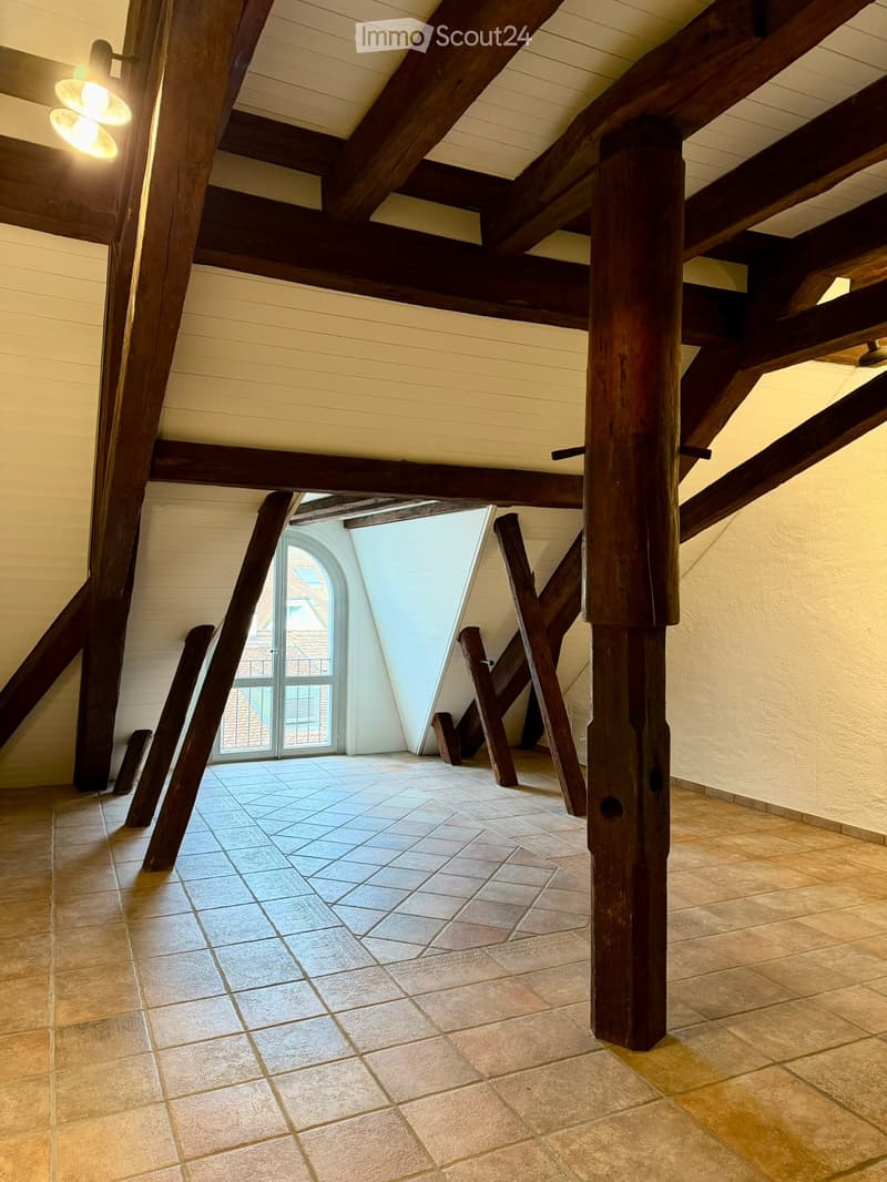 exposed wooden beams, arched window, tiled floor