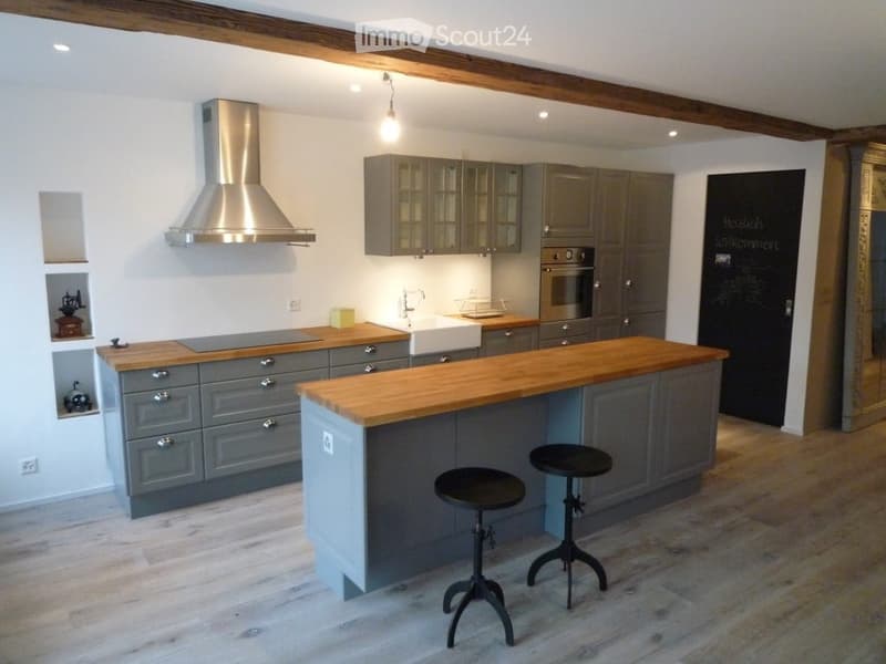 U-shaped kitchen, grey cabinets, wooden countertops, modern appliances, chandelier, open shelf, chalkboard, wooden floor