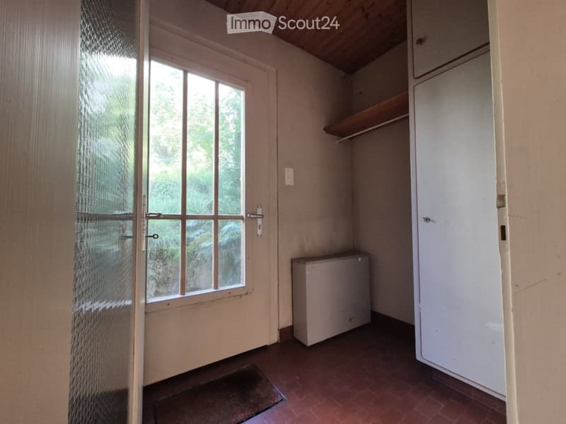 Empty room with wooden floor, white walls, a window with glass panels, a small built-in closet, and a radiator. No furniture or personal items are present.