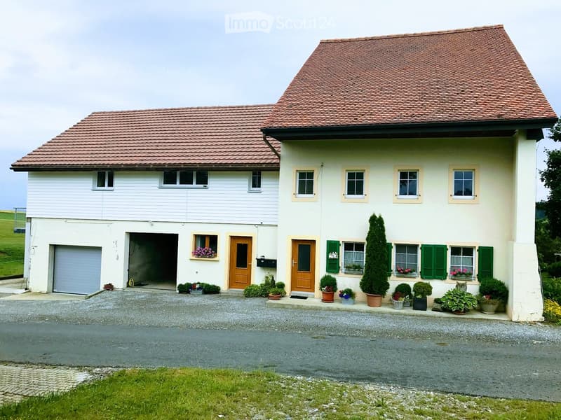 Two-story house with red-tiled roof, white siding, green shutters, garage, and flower boxes.