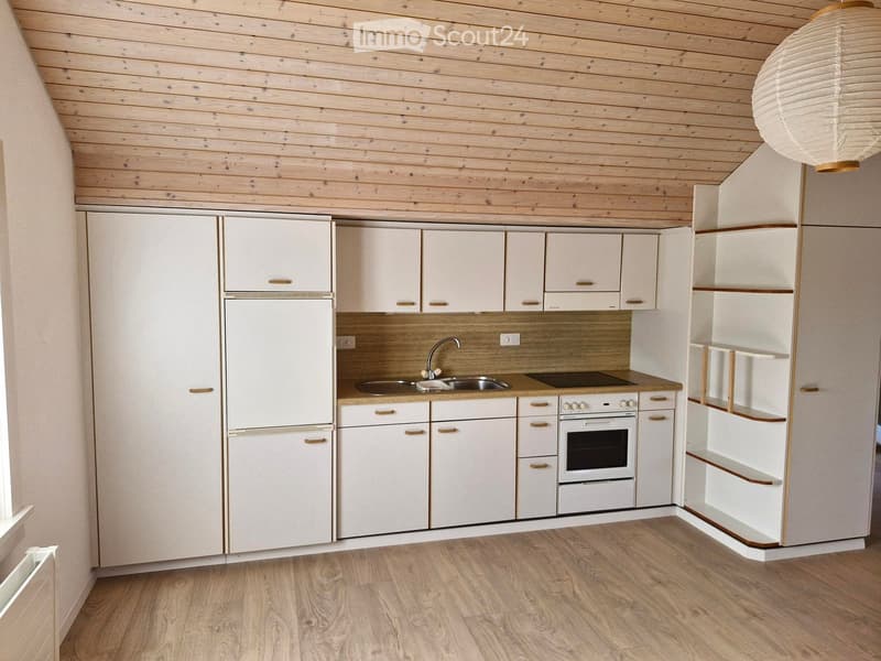 Modern kitchen with white cabinets, wooden countertops, stainless steel sink, and built-in appliances.