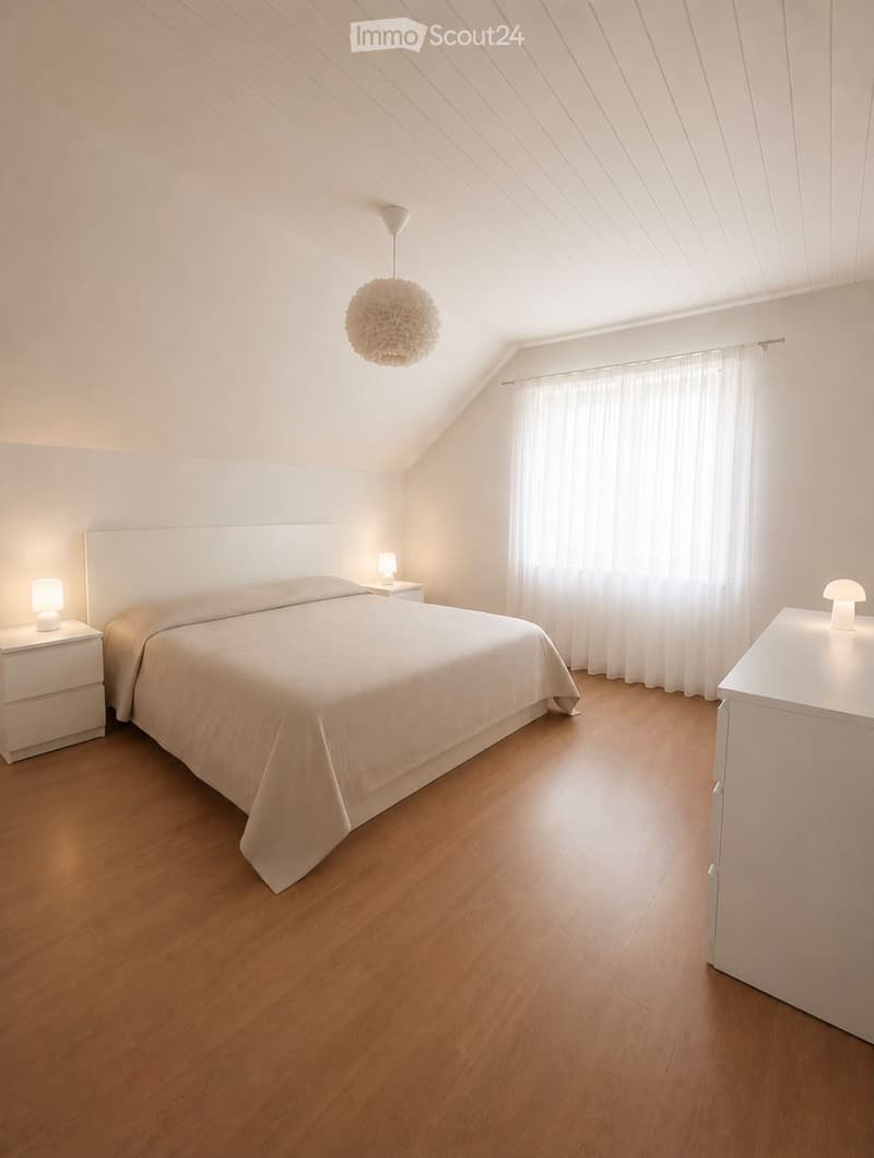 Bright bedroom with wooden flooring, a large bed with white bedding, two nightstands with lamps, and a hanging spherical light fixture.