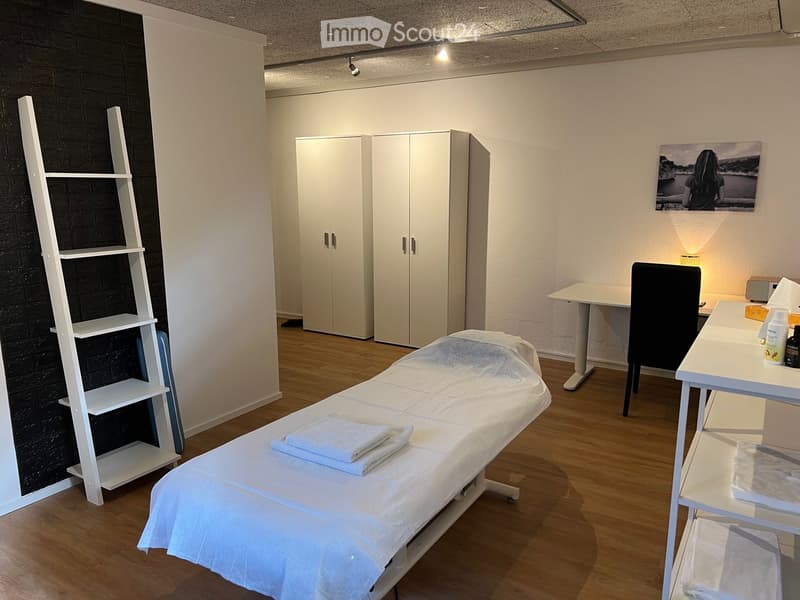 massage table, white shelves, white cabinets, desk, chair, picture frame, lamps