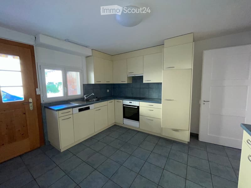 Modern kitchen with light-colored cabinets, a sink, an oven, and a dishwasher. The space features tiled flooring and ample natural light from windows.