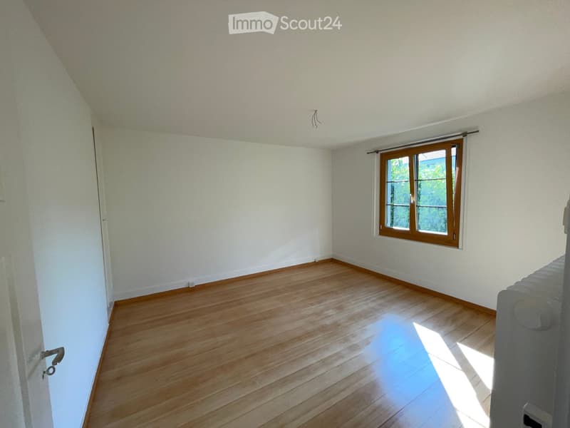 Empty room with wooden flooring, white walls, and a window with wooden frame and blinds. No furniture or equipment present.