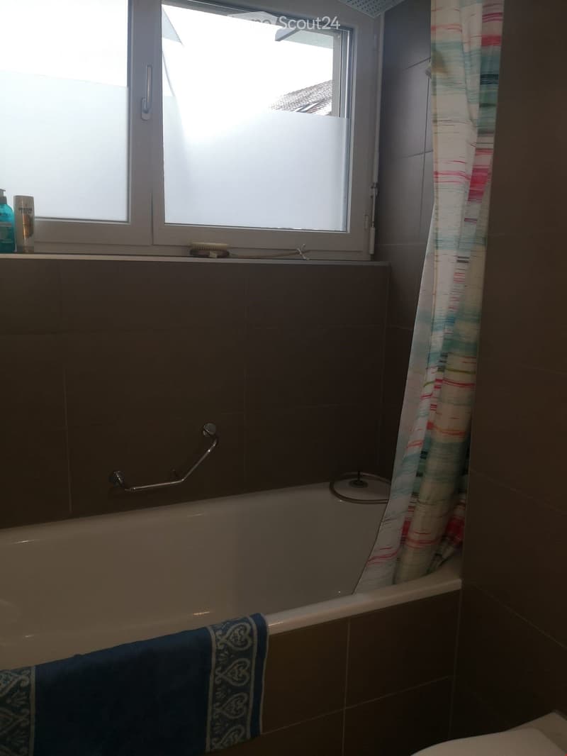 Bathroom with shower, bathtub, tile walls and floor, towels