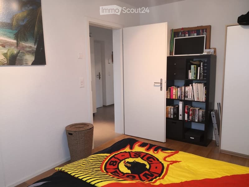 bedroom with bed, bookshelf, and hallway