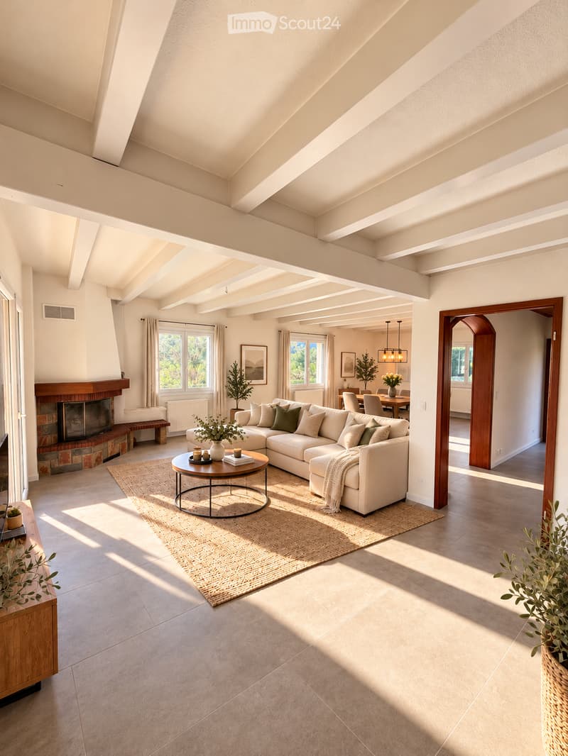 Bright living room with a large sectional sofa, coffee table, fireplace, and large windows letting in natural light.