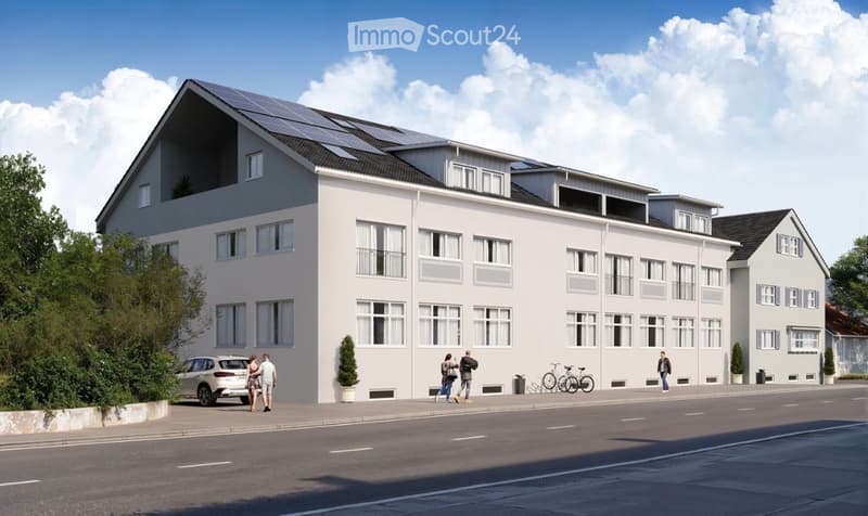 Modern multi-story residential building with white facade, large windows, and solar panels on the roof. Several people are walking along the sidewalk in front of the building.