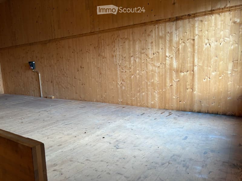empty room with wooden floor and walls, power outlet on the wall