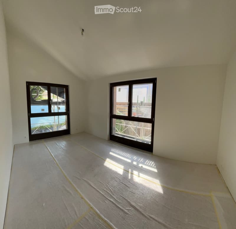 Unfurnished Room. Empty room with light-colored walls and a concrete floor, featuring two large windows that offer a view of a pool and outdoor area.