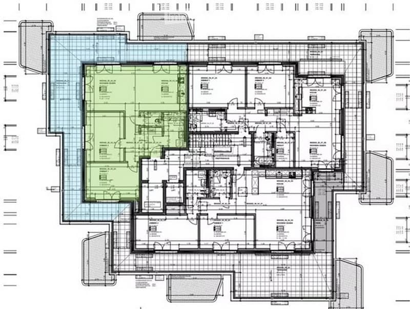 Floor plan of a large residential building with multiple rooms including living areas, bedrooms, bathrooms, and a central courtyard.