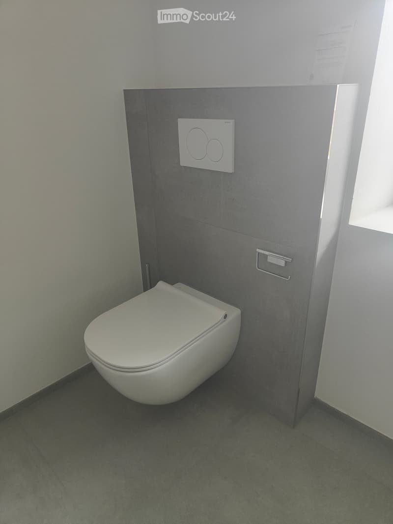 Bathroom: wall-hung toilet, gray tile wall, white floor