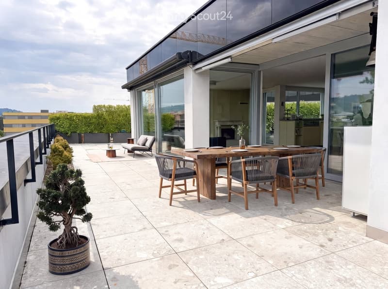 Modern rooftop terrace with a wooden dining table, six chairs, a lounge chair, a small side table, and a potted tree.