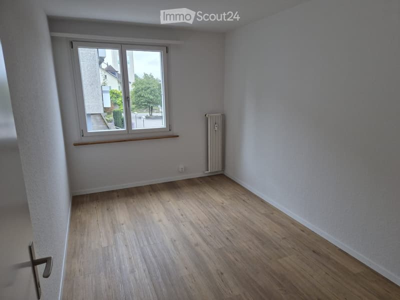 empty room, white walls, wooden floor, window with white frame, radiator