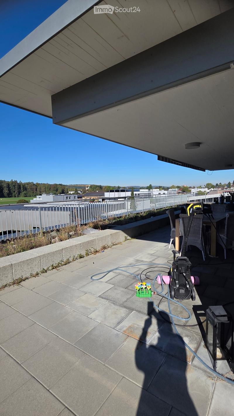 Balcony with tiled floor, metal railing, outdoor furniture, and a view of the surrounding area.