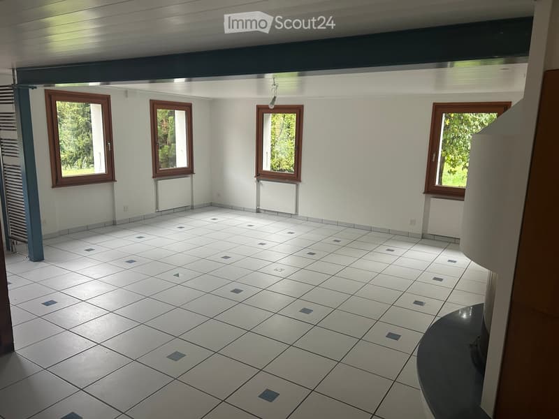 Empty room with white tiled floor, white walls, and four windows with wooden frames. The room has a modern, minimalist design with no furniture or decorations.