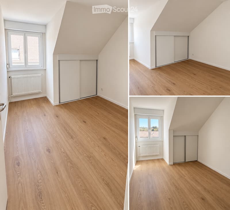 Empty attic room with wooden flooring, white walls, large window, and built-in closet. No furniture or personal items present.