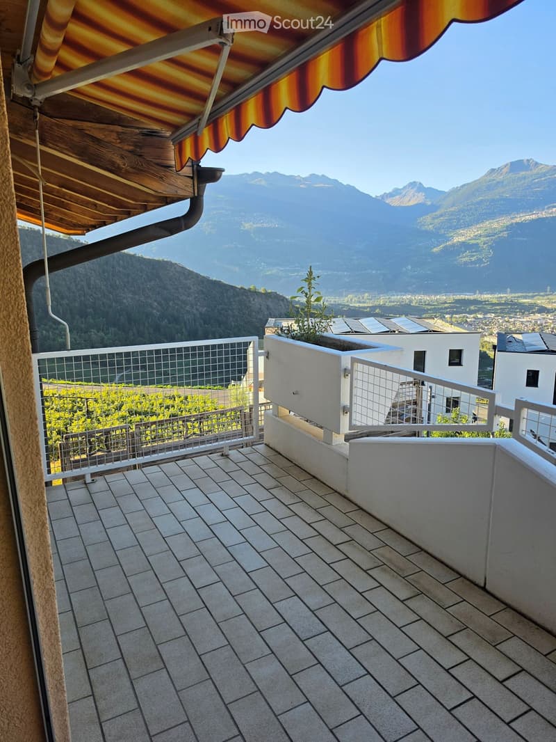 Balcony with tiled floor, metal railing, and scenic mountain view.