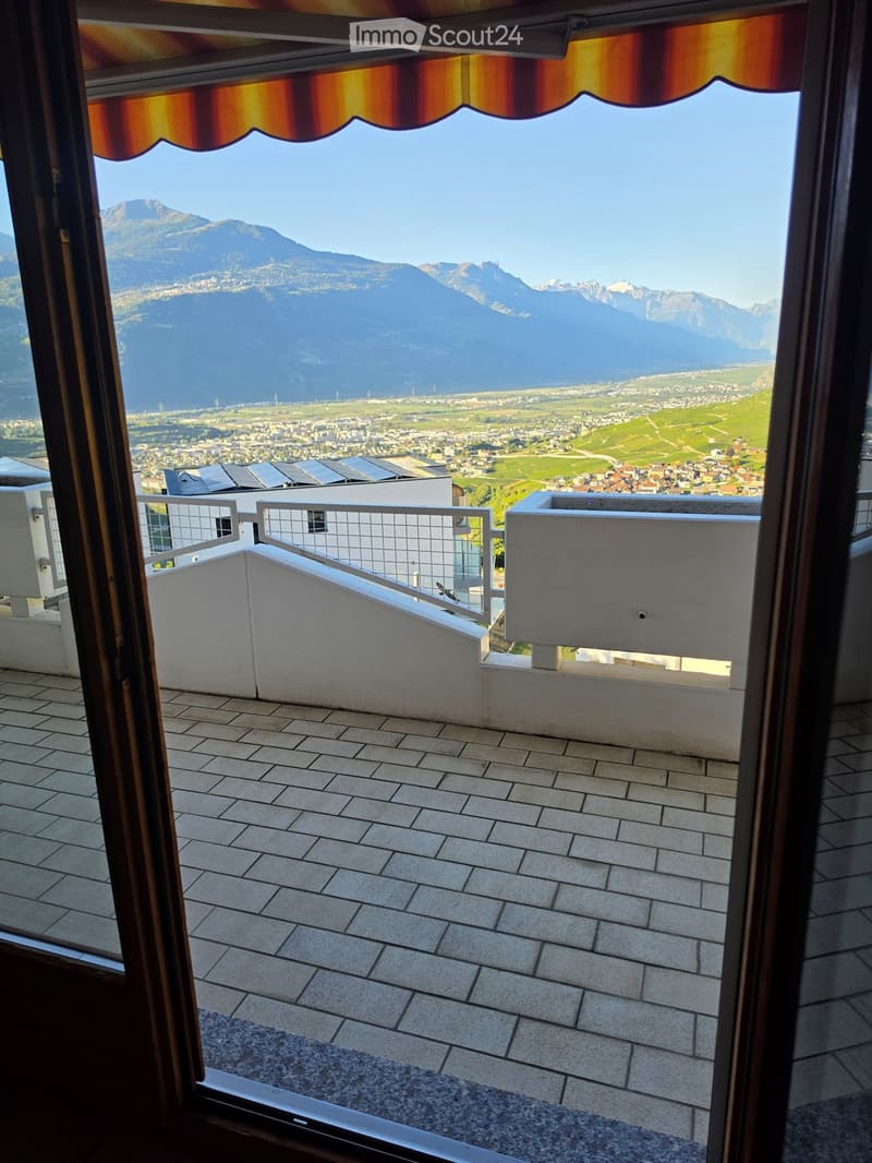 Balcony with tiled flooring, metal railing, and scenic mountain and city view.
