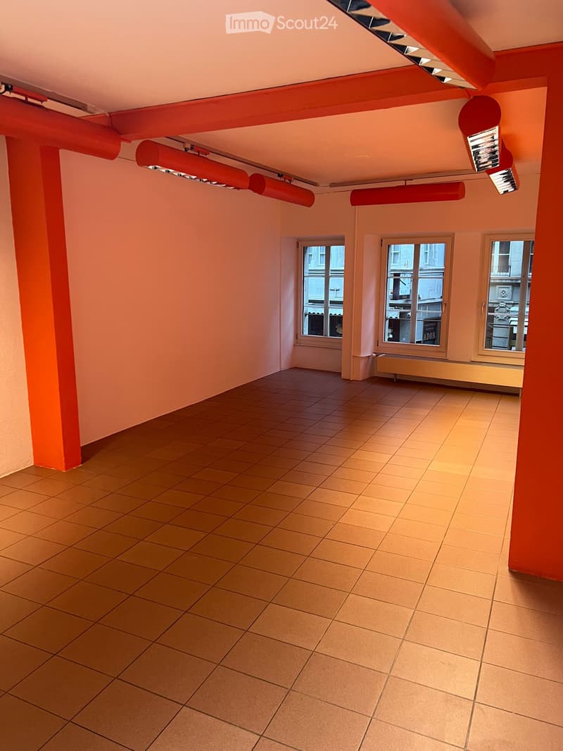 Empty room with tiled floor, light pink walls, and three windows. No furniture or equipment present.