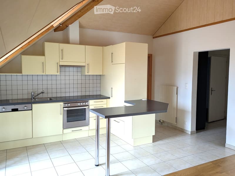 Modern kitchen with light-colored cabinets, stainless steel appliances, a central island, and tiled flooring.