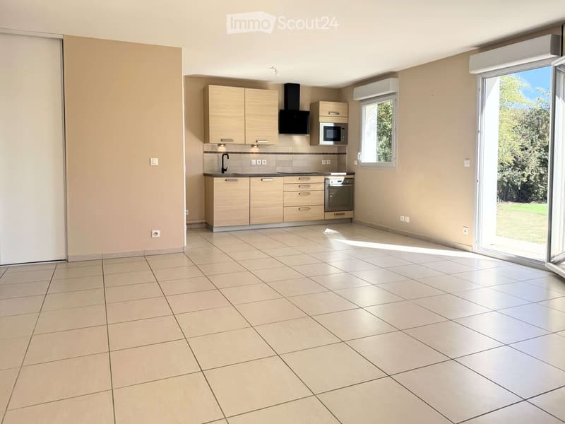 Modern kitchen with light wood cabinets, stainless steel appliances, tiled floor, and large windows with sliding glass doors leading to an outdoor area.