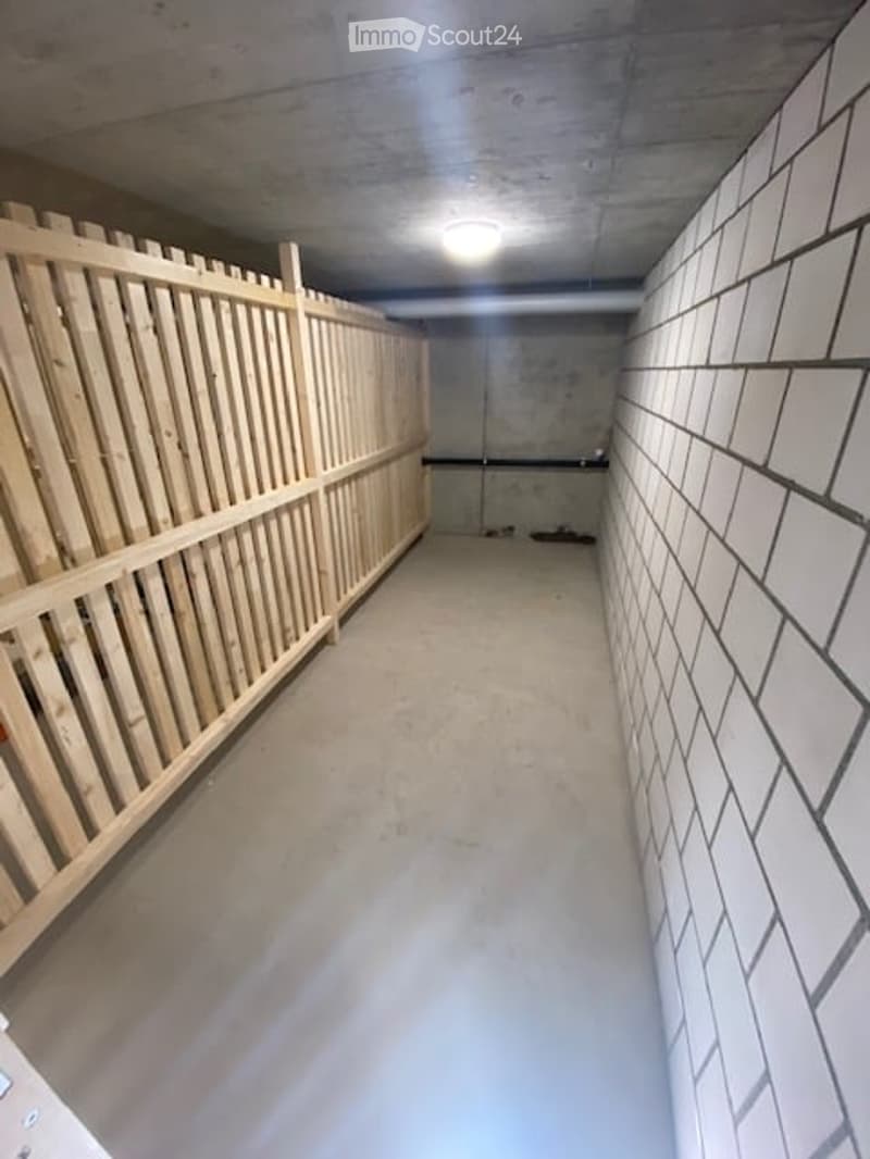 Empty concrete corridor with white tiled walls and a wooden barrier on one side.