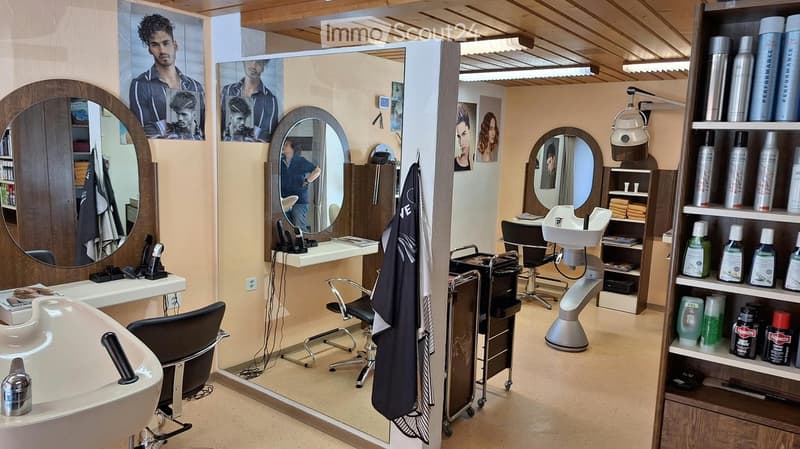 Modern salon with multiple mirrors, chairs, a styling stool, shelves with hair products, and a sink.