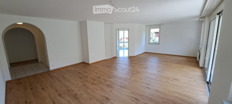 Empty room with wooden flooring, white walls, and large windows. No furniture or equipment present.